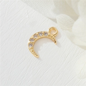 Macro detail of 14K gold plated crescent moon pendant with micro-inlaid cubic zirconia
