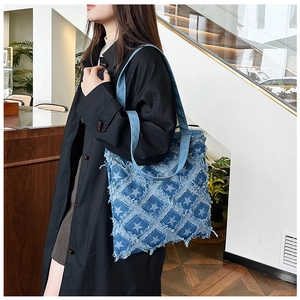 Close-up of vintage blue denim tote bag with frayed checkerboard and star pattern texture