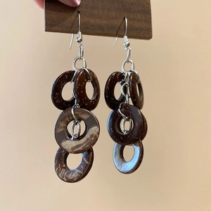 Detailed macro view of vintage coconut shell tassel drop earrings with natural textures