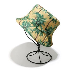 Dettaglio della stampa a palma tropicale su cappello a secchiello beige in cotone