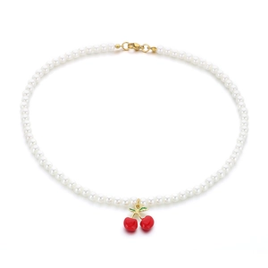 White pearl necklace featuring red resin cherry pendants and gold titanium steel clasp