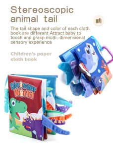 Detail of baby cloth book with textured dinosaur tails and plastic hanging ring toy