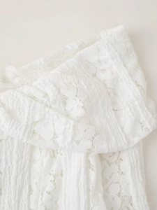 Gros plan sur la dentelle florale blanche élégante et les détails du tissu plissé de la robe