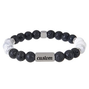 Macro detail of custom engraved stainless steel plate with black lava and marble beads