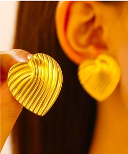 Detail of 18K gold-plated heart stud earrings with vertical pleated texture finish