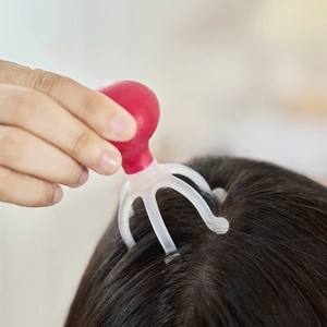Manual scalp massager with red handle for head relaxation and stress relief