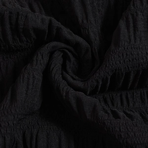 Macro shot of black pleated fabric showing elegant texture and soft draped material