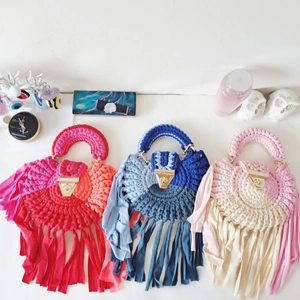 Detailed top view of handmade crochet tassel handbags with golden triangle metal clasps
