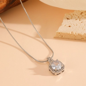 Macro shot of silver snake chain with hexagonal pendant and sparkling cubic zirconia stones
