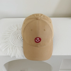 Detailed view of khaki twill cotton kids baseball cap with red embroidered smiley face