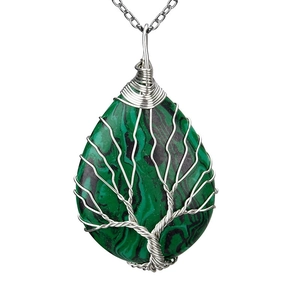 Macro shot of malachite stone pendant with silver wire tree of life wrap on white background