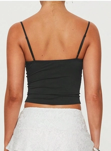 Detaillierte Rückansicht eines schwarzen schmalen Camisole-Tops und weißem Spitzenrock