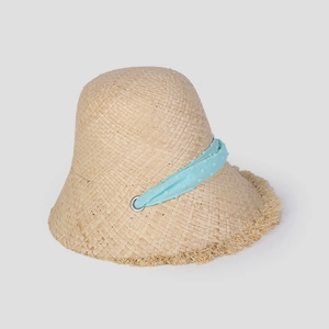 Close-up of beige raffia sun hat with blue polka dot ribbon and frayed edges detail