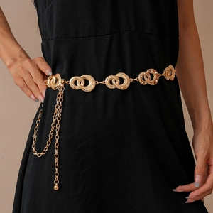 Detail of gold geometric interlocking chain belt with diamonds on a black dress