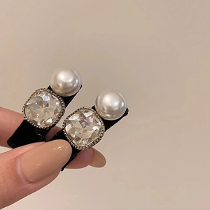 Gros plan sur des barrettes élégantes avec cristaux brillants et perles nacrées