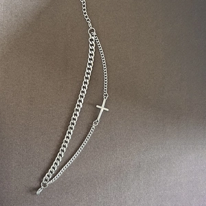 Vue macro du bracelet croix punk argenté à double couche avec éclat métallique sur fond gris