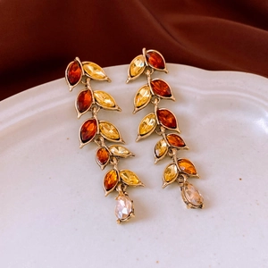 Detail of leaf-shaped amber crystal earrings with marquise and teardrop cuts on gold