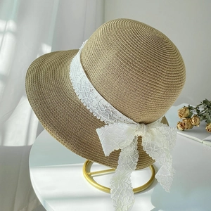 Chic beige straw sun hat for women featuring a delicate white lace ribbon and bow detail