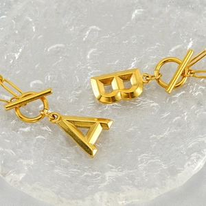 Gold stainless steel OT toggle necklace featuring minimalist A and B initial pendants