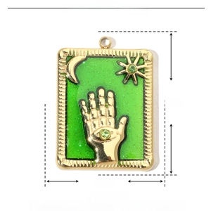 Detailed macro view of green enamel pendant with moon, stars and Hamsa hand on stainless steel