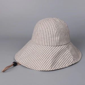 Dettaglio cappello da sole a righe in cotone e lino con cordino sottogola beige