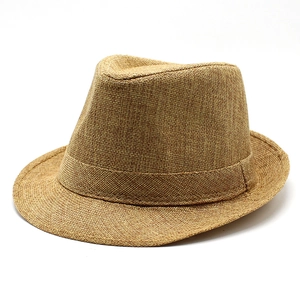 Gros plan sur le tressage en paille et la bande décorative d'un chapeau fedora marron