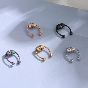 Five magnetic horseshoe nose rings in various colors on a soft blue background