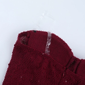 Detail of burgundy textured fabric with clear shoulder straps and invisible zipper closure