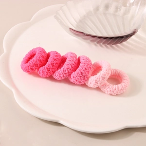 Set of 6 pink jacquard hair scrunchies displayed on a white ceramic wave plate
