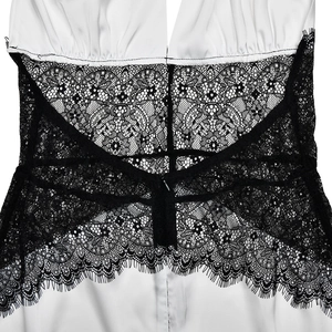 Nahaufnahme von weißem Satin und schwarzer Spitze an der Taille des eleganten Kleides