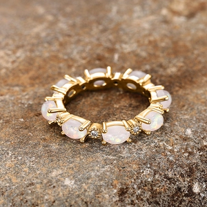 Détail macro d'une bague éternité en or avec opales blanches ovales et petits diamants