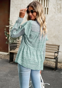 Detail of floral chiffon blouse featuring green base, white prints and ruffled long sleeves