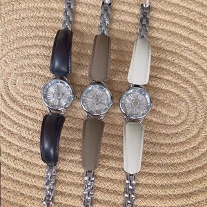 Detailed view of luxury watches featuring rotating snowflake dials and metal leather straps