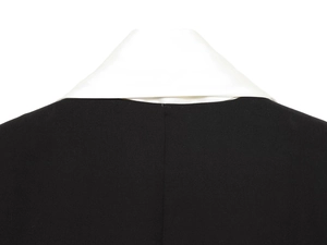 Close-up of black blazer collar with white shirt neck detail and premium fabric texture