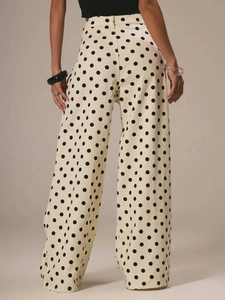 Rear view of women's vintage polka dot high-waisted wide-leg denim trousers in cream