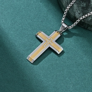 Men's two-tone stainless steel cross pendant with diamond-like inlay on green background