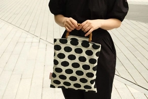 Close-up of vintage polka dot handbag featuring natural bamboo handles and ivory canvas