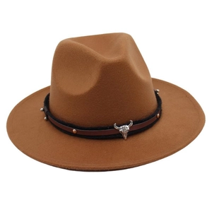Detail of western fedora hat with brown felt texture and bull skull metal buckle decoration