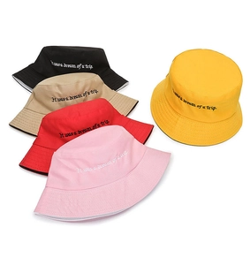 Detail of five cotton bucket hats with 'It was a dream of a trip' art embroidery