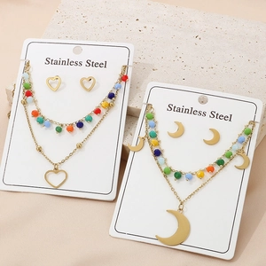 Detail of double-layer stainless steel heart and moon necklaces with colorful beads