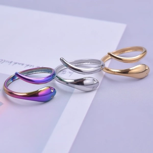 Three minimalist snake-shaped stainless steel rings in gold, silver, and rainbow colors