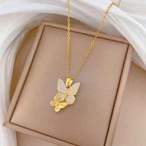 Macro detail of gold-plated double butterfly pendant necklace with sparkling cubic zirconia