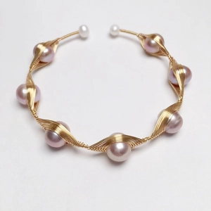 Detail of 14K gold-filled wire wrapped bracelet featuring pink freshwater pearls