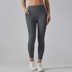 Detail of dark grey high-waisted yoga pants showing the functional side phone pocket