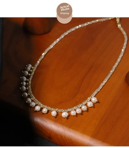 Macro detail of natural pearl necklace with gold beads on a warm wooden display
