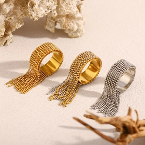 Detail of bohemian gold and silver beaded tassel rings on a natural stone background