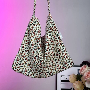 Close-up of floral pattern canvas tote bag with MAUD label and triangle structure