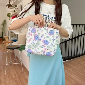 Close-up of floral canvas storage bag held by a model to show actual size and texture