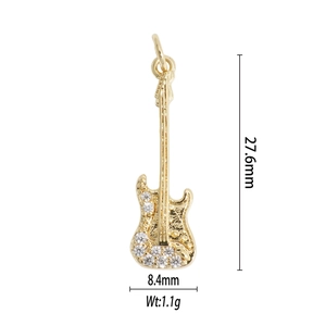Detailed view of a gold guitar pendant with rhinestones and size dimensions 27.6mm by 8.4mm
