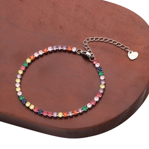 Rainbow cubic zirconia tennis bracelet on a wooden base with adjustable heart charm